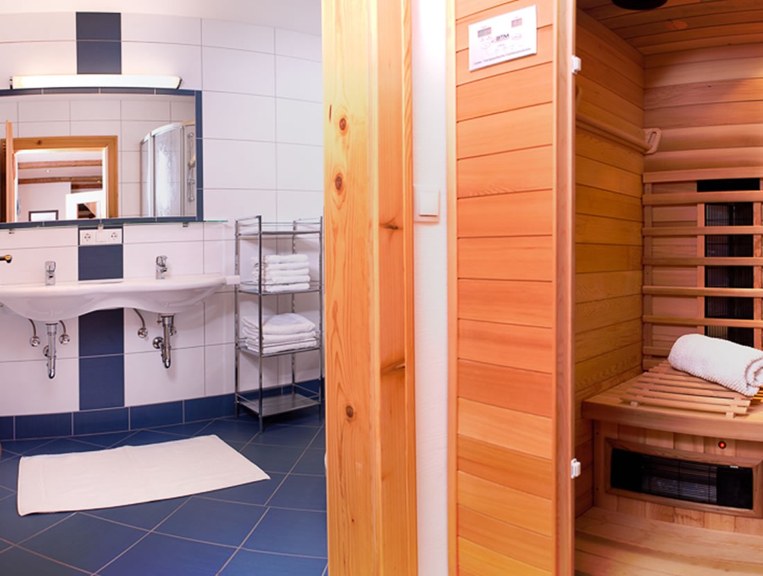 Badezimmer mit Doppelwaschbecken und Infrarotkabine