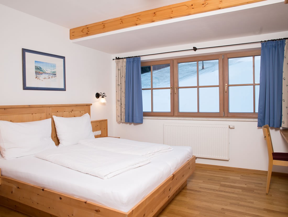 Gemütliches Schlafzimmer mit Doppelbett direkt an der Skipiste