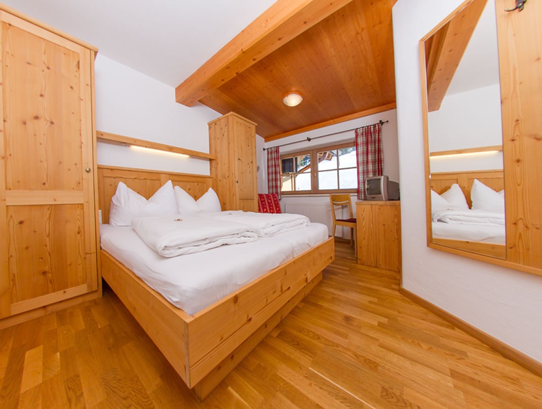 Schlafzimmer mit Doppelbett und Vollholzmöbeln